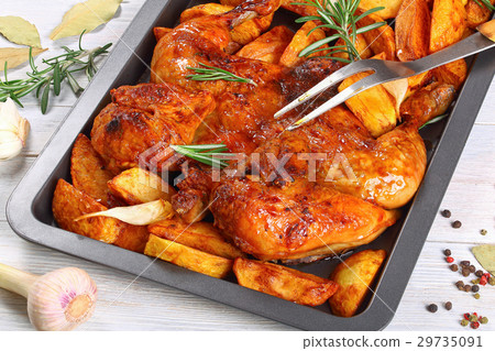 chicken on baking tray with potato wedges 29735091