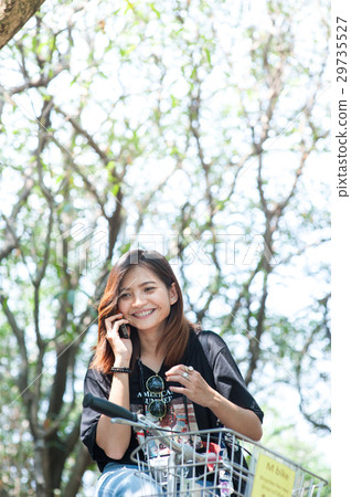 woman on a bicycle talking on the mobile phone 29735527