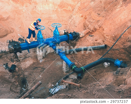 Worker in safety clothes. City potable water pipe Worker in safety clothes. City potable water pipe 29737237