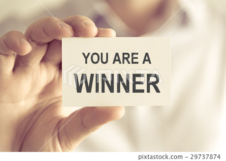 Businessman holding YOU ARE A WINNER message card Businessman holding YOU ARE A WINNER message card 29737874