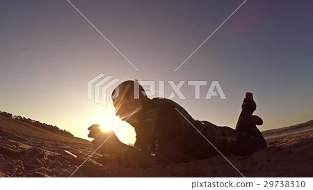 Portable console. Man lies on the sand and plays 29738310