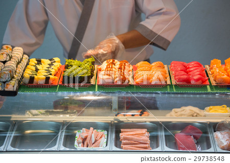sashimi and nigiri on sushi bar with blurred chef 29738548