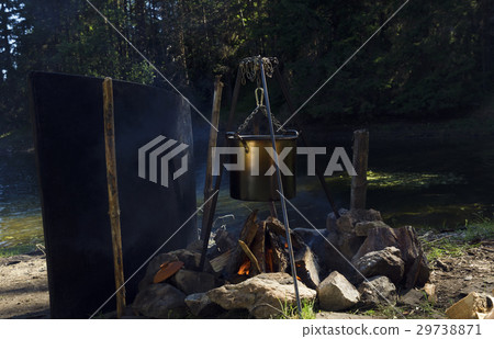 Camping fire in the wood next to lake 29738871