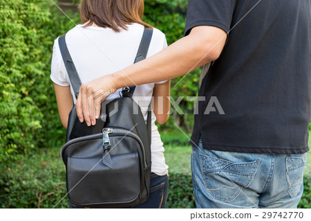 Thief trying to steal the wallet in the backpack 29742770