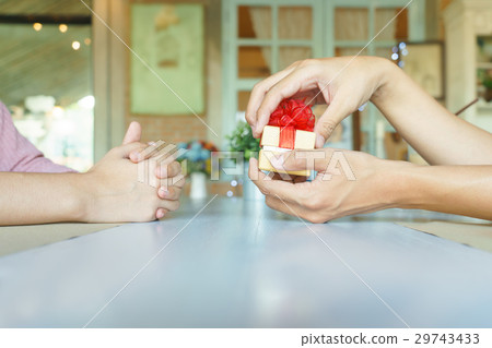 Man hands opening a present box with red ribbon Man hands opening a present box with red ribbon 29743433