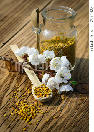 Grains of bee pollen in jar and wooden spoon on Grains of bee pollen in jar and wooden spoon on 29744283