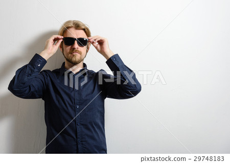 Stylish man in blue shirt and sunglasses standing Stylish man in blue shirt and sunglasses standing 29748183