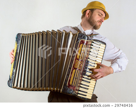 Portrait of nan in straw hat playing on accordion 29748416