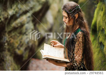 Young female elf wandering in the forest holding 29748561