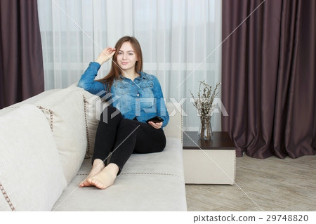 Beautiful young woman watching television Beautiful young woman watching television 29748820