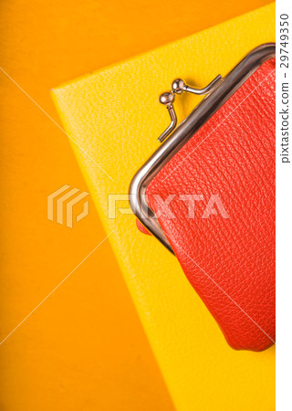 Orange wallet on a yellow notebook Orange wallet on a yellow notebook 29749350