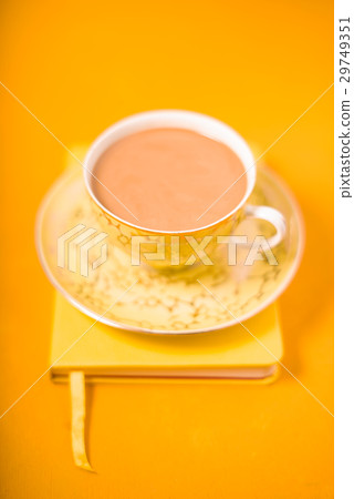 Cup and saucer and coffee with milk on a yellow Cup and saucer and coffee with milk on a yellow 29749351