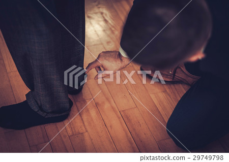 Tailor measuring client for custom made garment 29749798