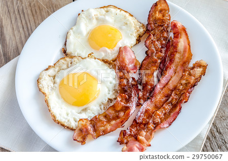 Fried eggs with bacon on the wooden table 29750067
