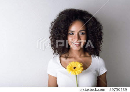 Young smiling woman holding a flower Young smiling woman holding a flower 29750589