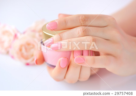 Hands of a woman with pink manicure with cream Hands of a woman with pink manicure with cream 29757408