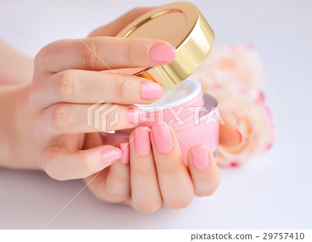 Hands of a woman with pink manicure with cream 29757410