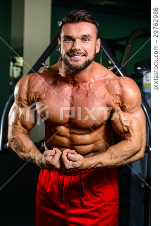 Handsome fit muscular man flexing muscles in gym 29762986