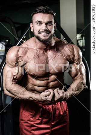 Handsome fit muscular man flexing muscles in gym Handsome fit muscular man flexing muscles in gym 29762989