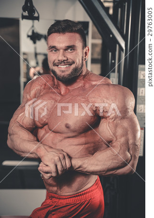 Handsome fit muscular man flexing muscles in gym Handsome fit muscular man flexing muscles in gym 29763005
