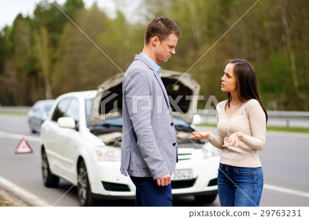 Couple near broken car on a highway roadside 29763231