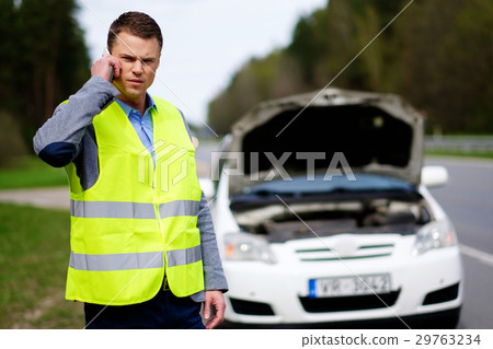Man calling car towing service on a highway Man calling car towing service on a highway 29763234