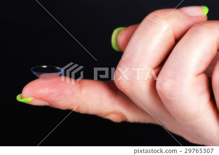 A soft contact lens on the female finger A soft contact lens on the female finger 29765307