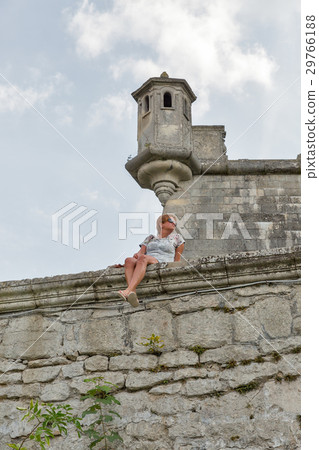 Woman and watch tower of ruined Pidhirtsi Castle 29766188