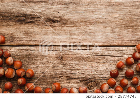 Wooden background with hazelnuts border free space 29774745