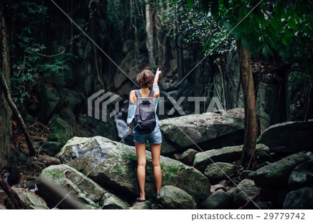 Back of woman with backpack in tropical jungle Back of woman with backpack in tropical jungle 29779742