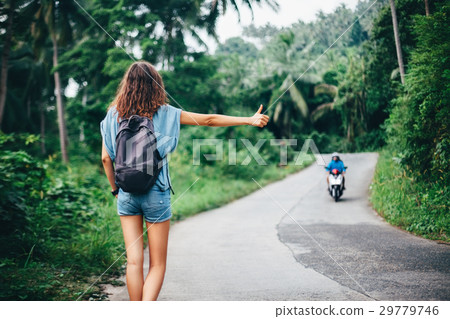 Young beautiful woman hitchhiking standing on road Young beautiful woman hitchhiking standing on road 29779746