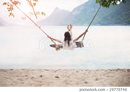 Carefree happy woman on swing on paradises beach Carefree happy woman on swing on paradises beach 29779748