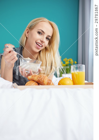 Young beautiful woman having breakfast in bed. Young beautiful woman having breakfast in bed. 29781867
