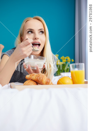 Young beautiful woman having breakfast in bed. Young beautiful woman having breakfast in bed. 29781868