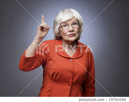 Senior lady points finger up 29782088
