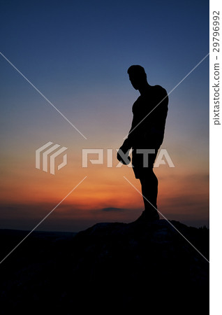 Dark silhouette of a muscular male boxer outdoors Dark silhouette of a muscular male boxer outdoors 29796992