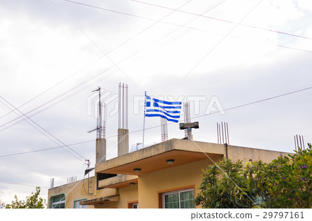 Greek flag on the roof of building, waving in the Greek flag on the roof of building, waving in the 29797161