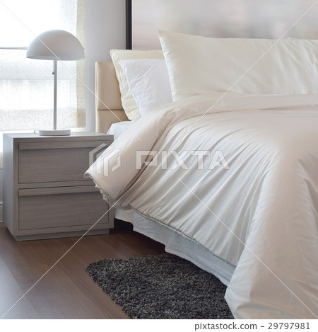 Cozy bedroom with pillows and reading lamp Cozy bedroom with pillows and reading lamp 29797981