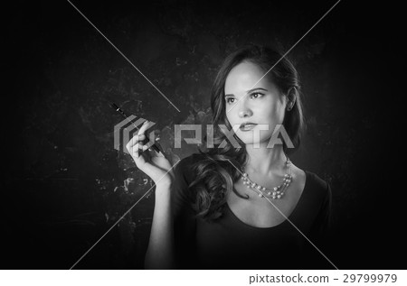 Noir film style woman in dress holding cigarette Noir film style woman in dress holding cigarette 29799979