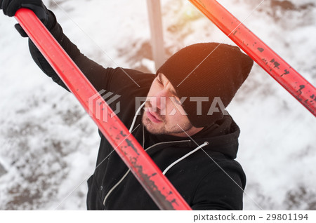 Male adult in black sportswear exercising on bars 29801194