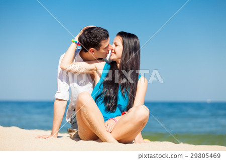 photo of cute couple sitting on the beach photo of cute couple sitting on the beach 29805469