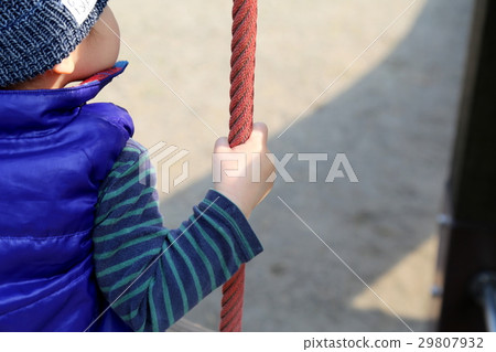 Infant hand riding on a swing 29807932