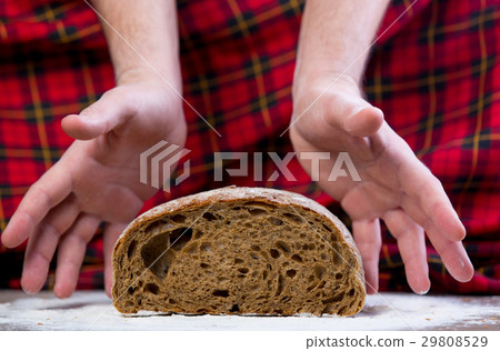 male hand under bread loaf male hand under bread loaf 29808529