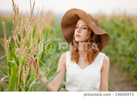 young woman standing near the growing corn 29808973