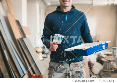 A young man at work. Painter with a brush. Concept A young man at work. Painter with a brush. Concept 29809384