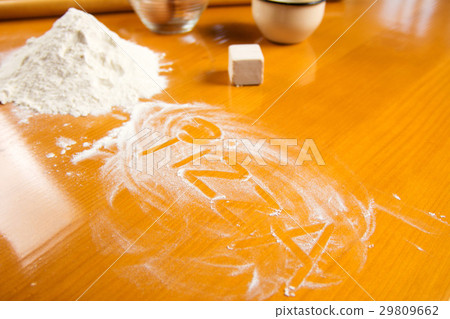 Word pizza written in flour on kitchen table Word pizza written in flour on kitchen table 29809662