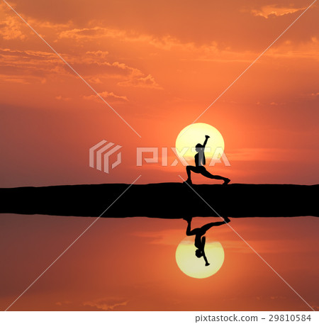 Silhouette of a standing woman practicing yoga 29810584