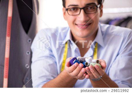 Young man tailor working on new clothing Young man tailor working on new clothing 29811992