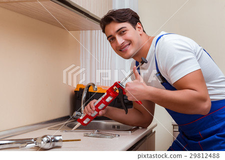 Young repairman working at the kitchen 29812488