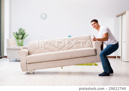 Young man moving furniture at home Young man moving furniture at home 29812740